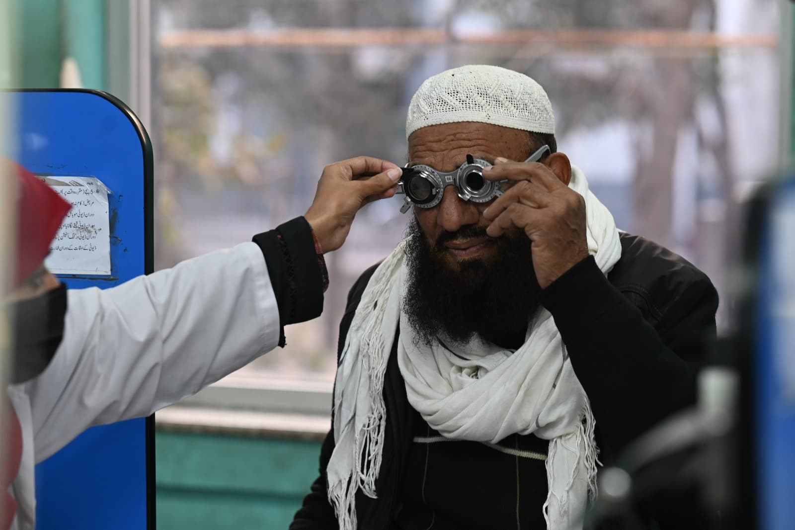 Elderly patient fitted with trial frames during an eye exam